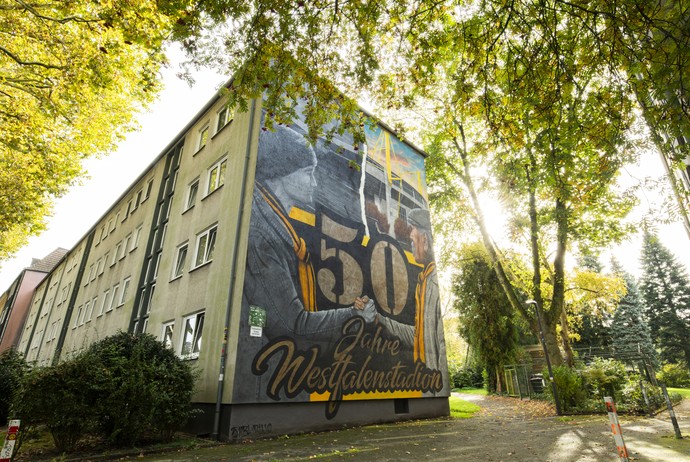 Die Künstler Amar Jakupovic und Andrian Schnabel (SNBL Arts) schufen dieses Wandbild anlässlich des 50-jährigen Jubiläums des Westfalenstadions. Die Künstler Amar Jakupovic und Andrian Schnabel (SNBL Arts) schufen dieses Wandbild anlässlich des 50-jährigen Jubiläums des Westfalenstadions. (vergrößerte Bildansicht wird geöffnet)